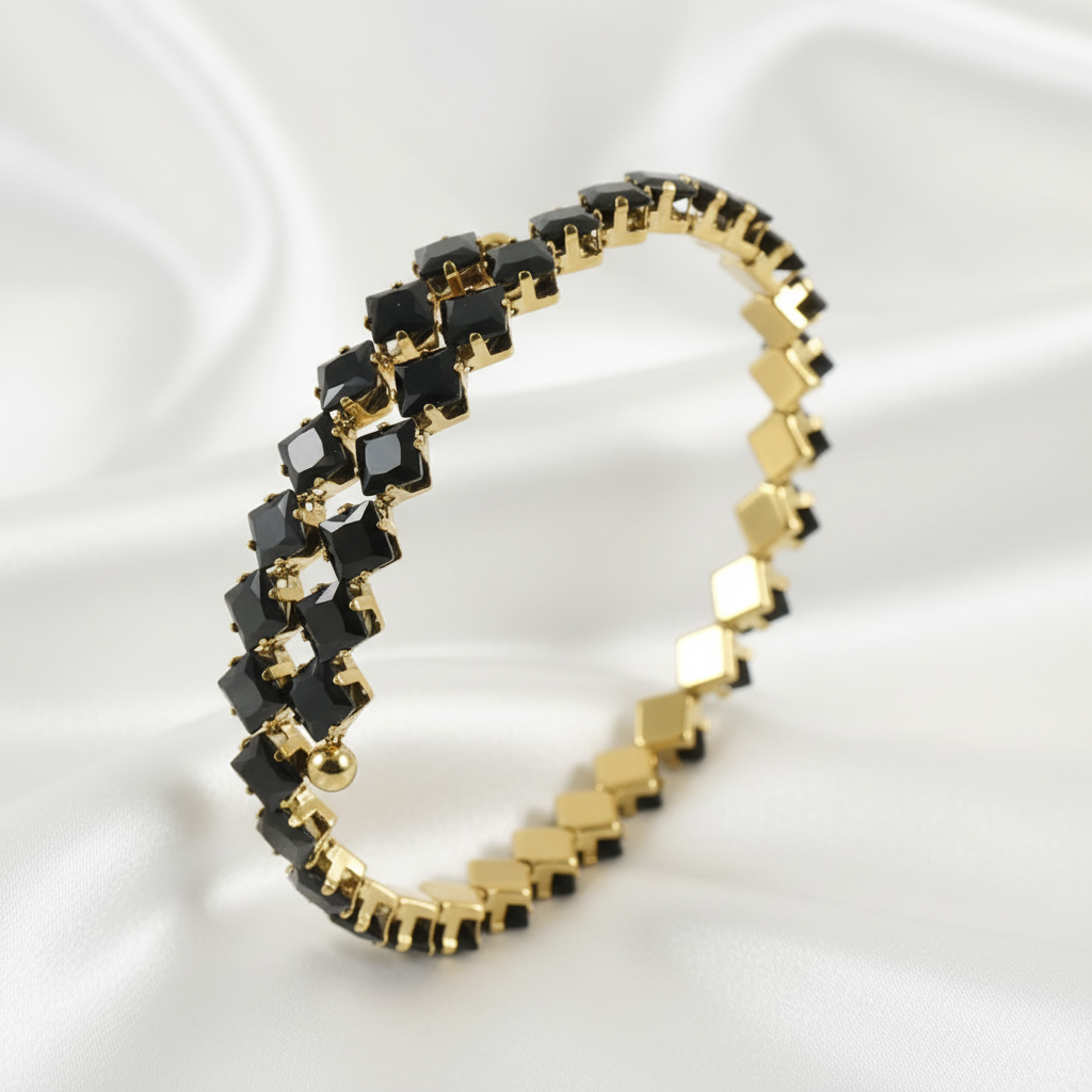 Guldigt armband med svarta stenar